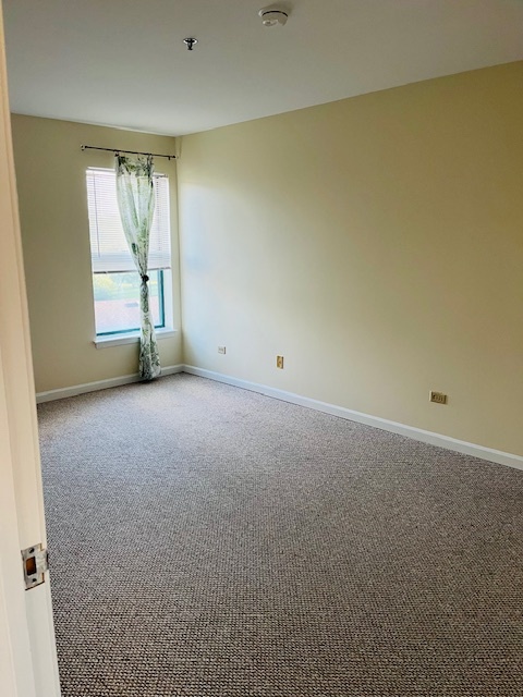 3275 Kirchoff Road, Unit 337 Rolling Meadows, IL 60008 - Photo 4 of 10 an empty room with windows