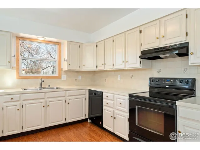 a kitchen with stainless steel appliances granite countertop a stove a sink and white cabinets