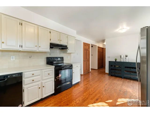 a kitchen with stainless steel appliances white cabinets and a refrigerator