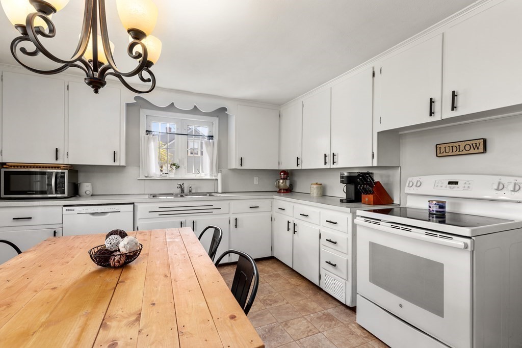 53 Wilson Street Ludlow, MA 01056 - Photo 8 of 26 a kitchen with stainless steel appliances granite countertop a sink a stove oven a white counter space and cabinets