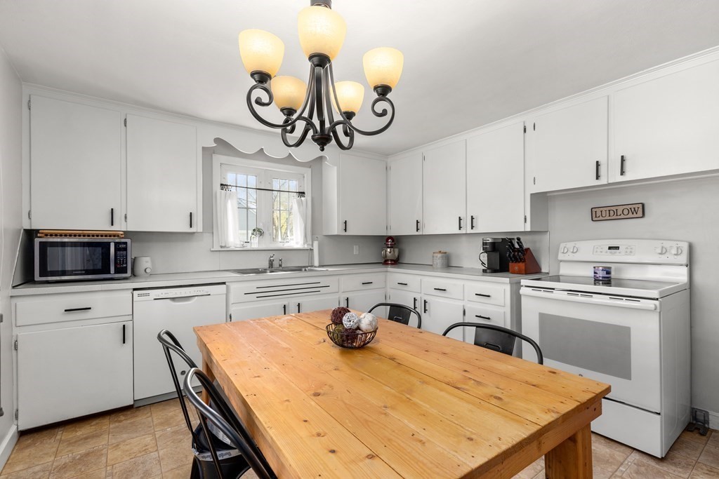 53 Wilson Street Ludlow, MA 01056 - Photo 9 of 26 a kitchen with a table chairs and white cabinets
