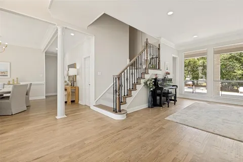 a kitchen with stainless steel appliances kitchen island granite countertop a stove a sink a refrigerator and white cabinets with wooden floor