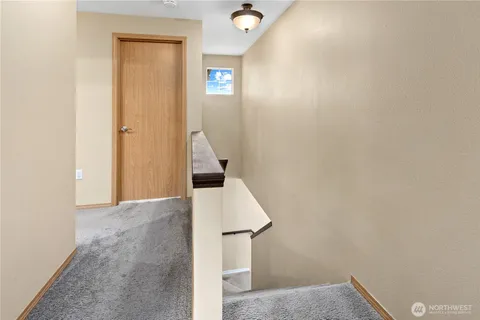a view of a hallway with white walls and wooden floor