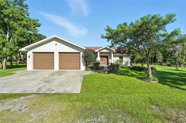 a front view of a house with a yard and trees