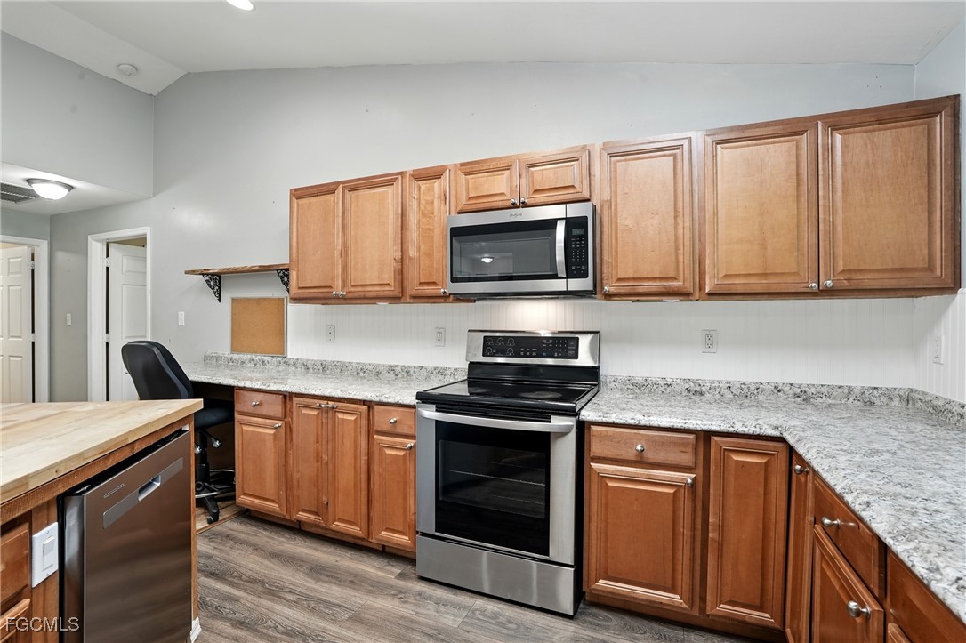 2373 Summerall Road LaBelle, FL 33935 - Photo 14 of 47 a kitchen with granite countertop a stove top oven microwave and cabinets