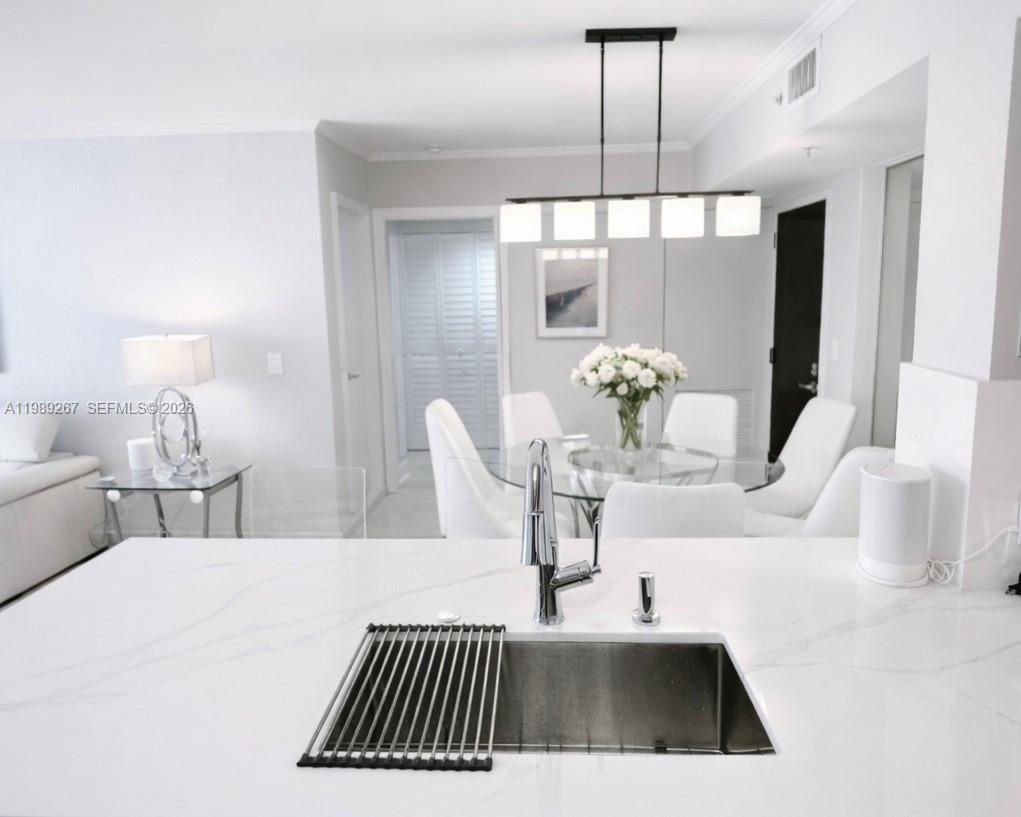 90 Alton Road, Unit 803 Miami Beach, FL 33139 - Photo 11 of 23 a close view of dining table chairs and chandelier