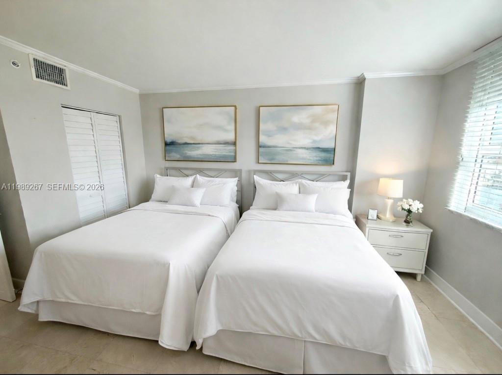90 Alton Road, Unit 803 Miami Beach, FL 33139 - Photo 14 of 23 a bedroom with a bed and large window