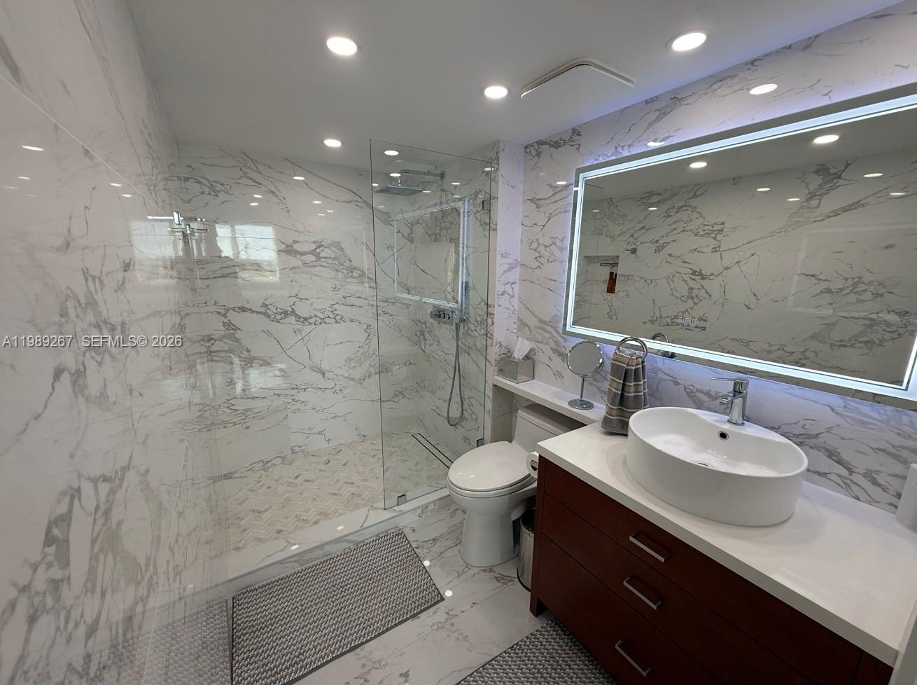 90 Alton Road, Unit 803 Miami Beach, FL 33139 - Photo 7 of 23 a bathroom with a double vanity sink toilet and shower