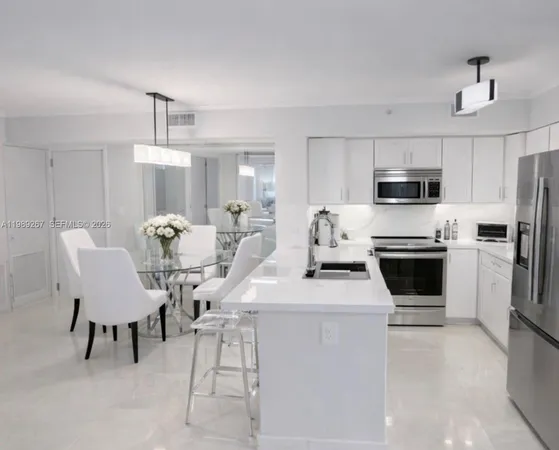 a kitchen with a white cabinets and chairs and a refrigerator