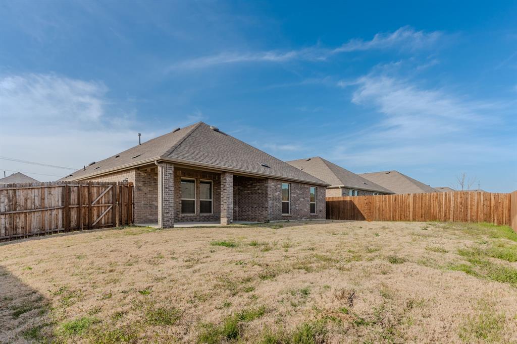 2902 Trusting Way Aubrey, TX 76227 - Photo 34 of 38 Expansive backyard featuring a brick exterior, covered patio, and privacy fencing