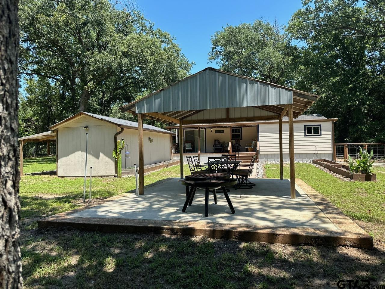 223 Holly Glen Murchison, TX 75778 - Photo 29 of 34 a view of backyard with table and chairs under an umbrella