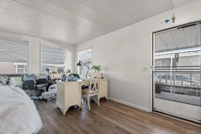 a living room with furniture a window and wooden floor