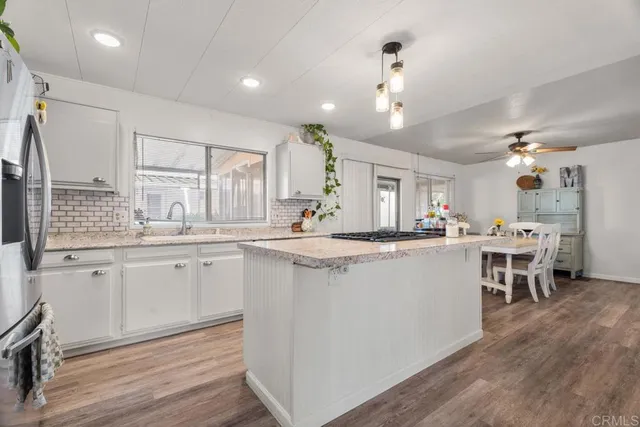 a kitchen with kitchen island granite countertop a sink stove and refrigerator