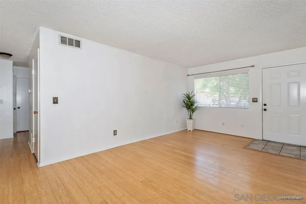 9845 Mission Gorge Road, Unit 4 Santee, CA 92071 - Photo 9 of 25 a view of an empty room with wooden floor and a window