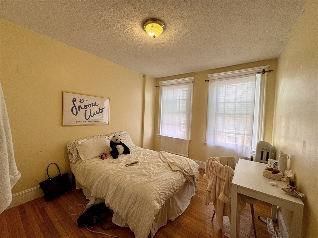 50 Chester Street, Unit 10 Boston, MA 02134 - Photo 9 of 13 a bedroom with a bed and wooden floor