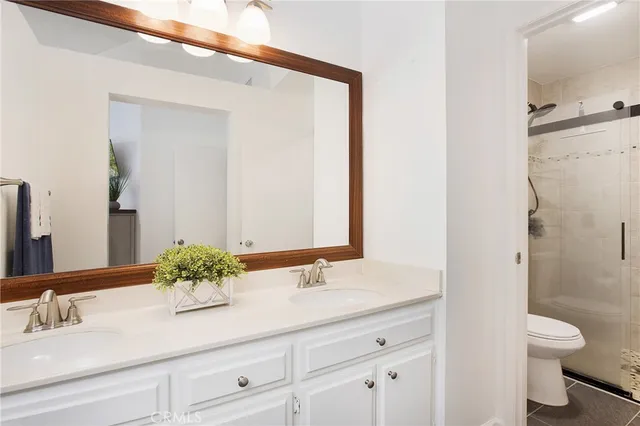 a bathroom with a sink a toilet and a large mirror