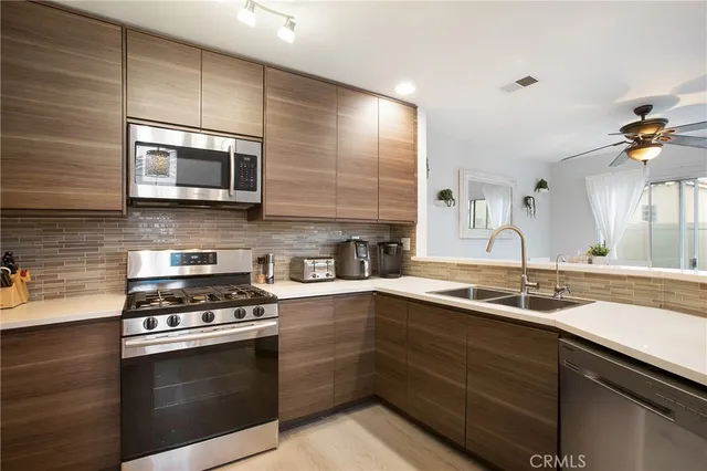a kitchen with stainless steel appliances a stove sink microwave and cabinets