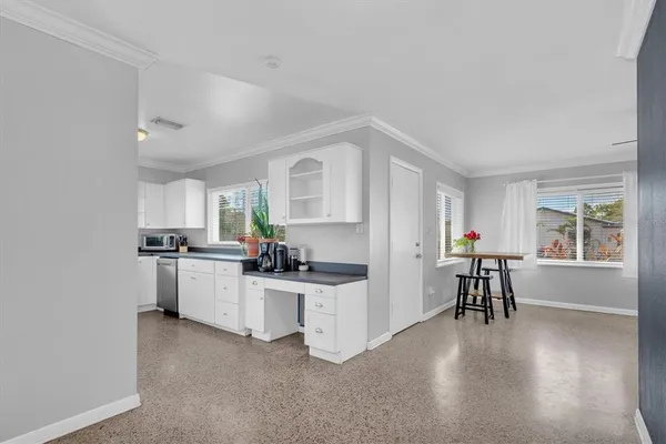 a kitchen with white cabinets and appliances