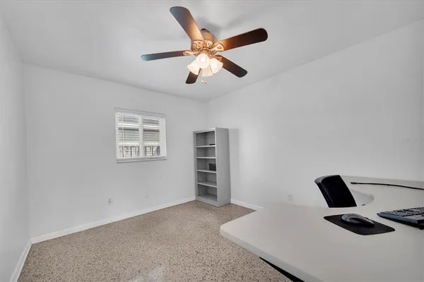 a work room with furniture and a ceiling fan