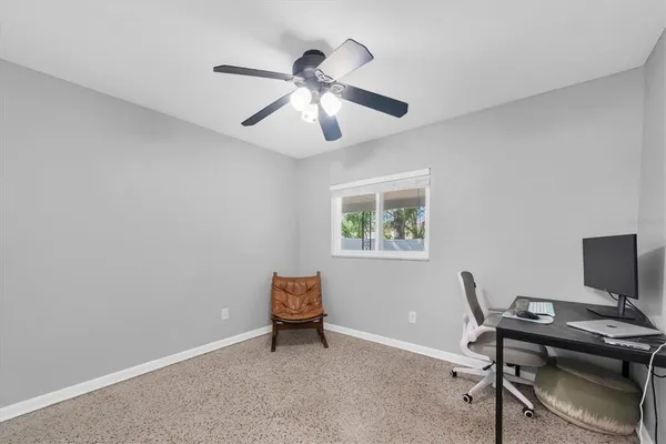 a view of a workspace with furniture and a window