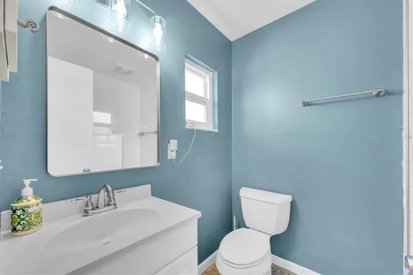 a bathroom with a toilet sink vanity and mirror