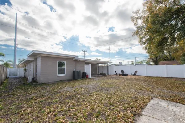 a view of a house with a yard and fence