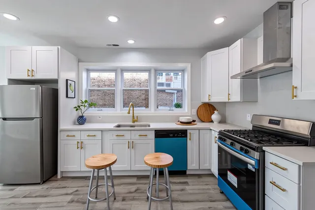 a kitchen with stainless steel appliances a stove a sink refrigerator and cabinets
