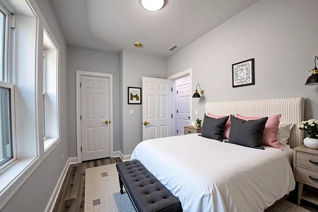 a bedroom with a bed and a large mirror on the dresser