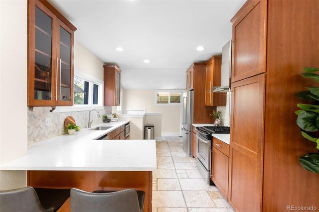 a kitchen with stainless steel appliances granite countertop a sink and a refrigerator
