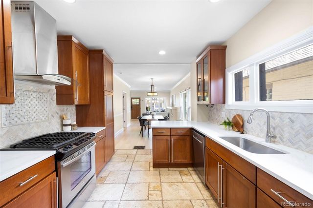 a large kitchen with stainless steel appliances granite countertop a stove and a sink