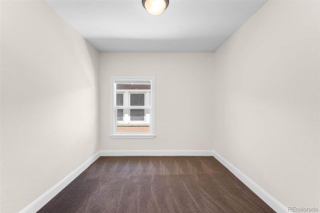 a view of a room that has wooden floor and window