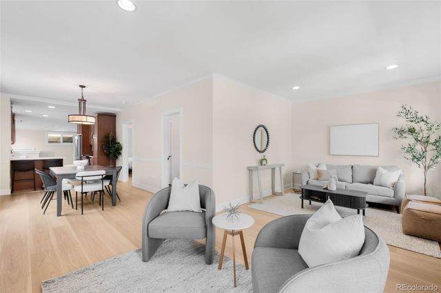 a living room with furniture kitchen view and a large window