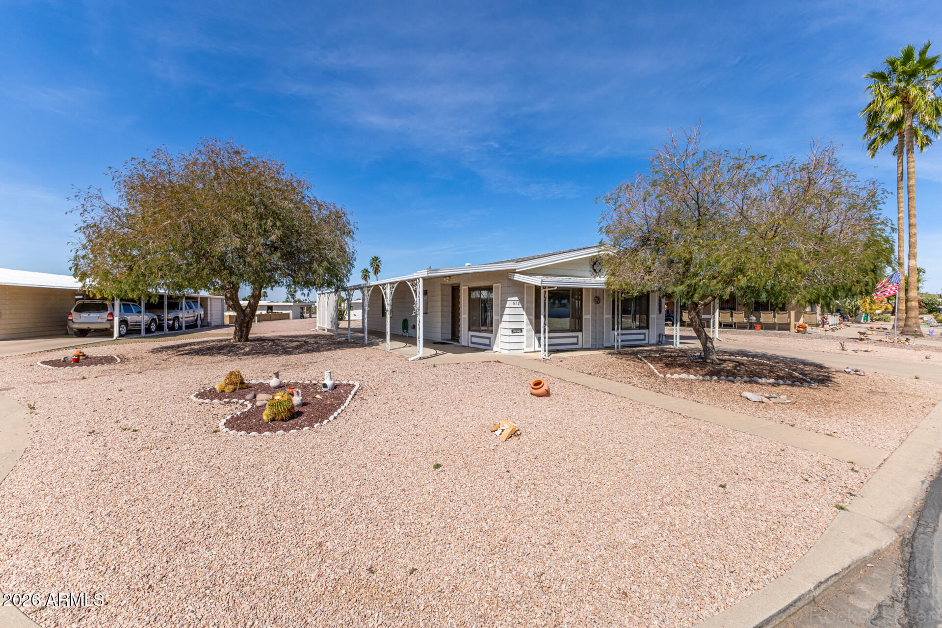 512 South 83rd Way Mesa, AZ 85208 - Photo 12 of 45 a backyard of a house with table and chairs under an umbrella