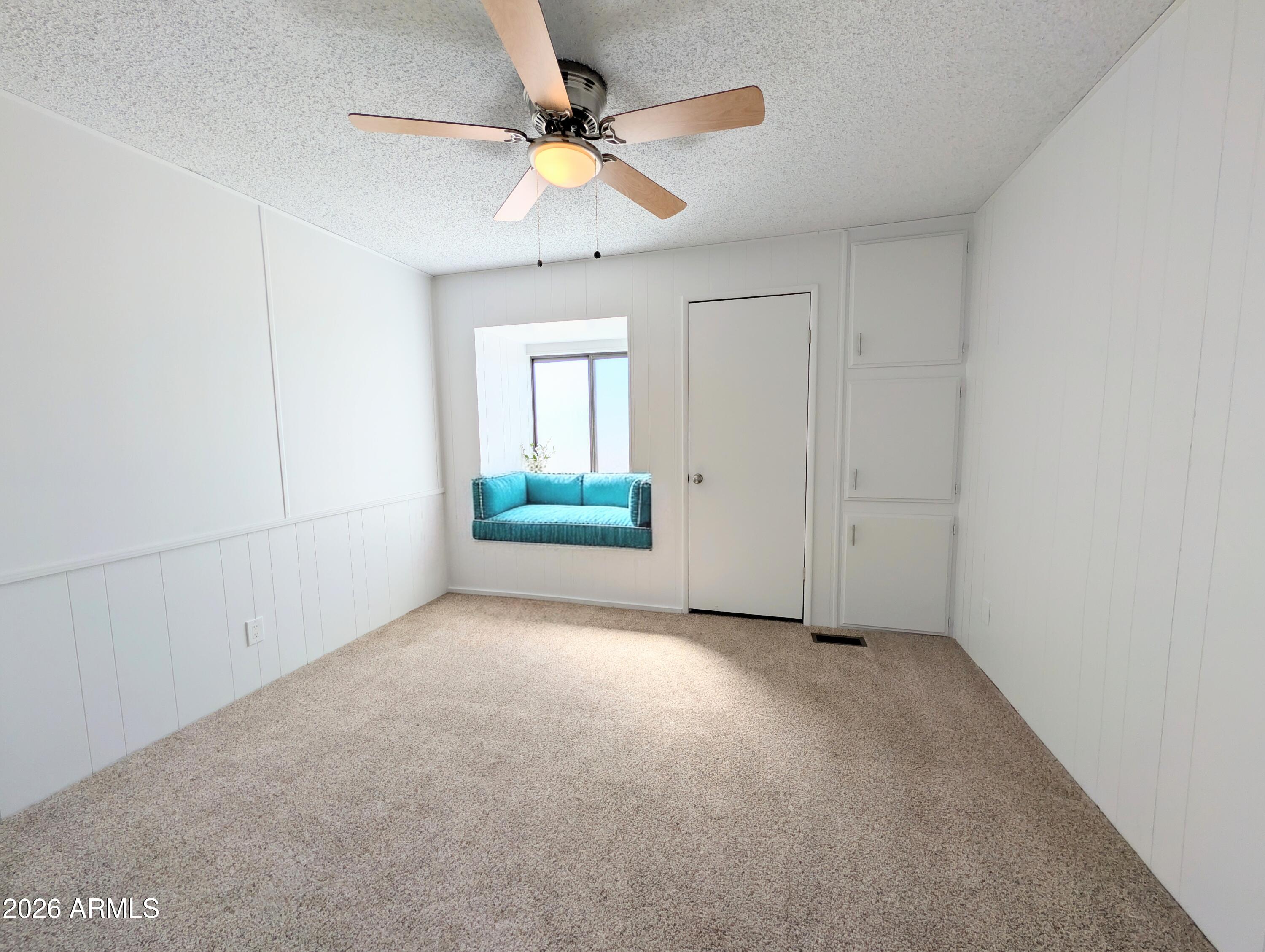 512 South 83rd Way Mesa, AZ 85208 - Photo 32 of 45 an empty room with a ceiling fan and a window