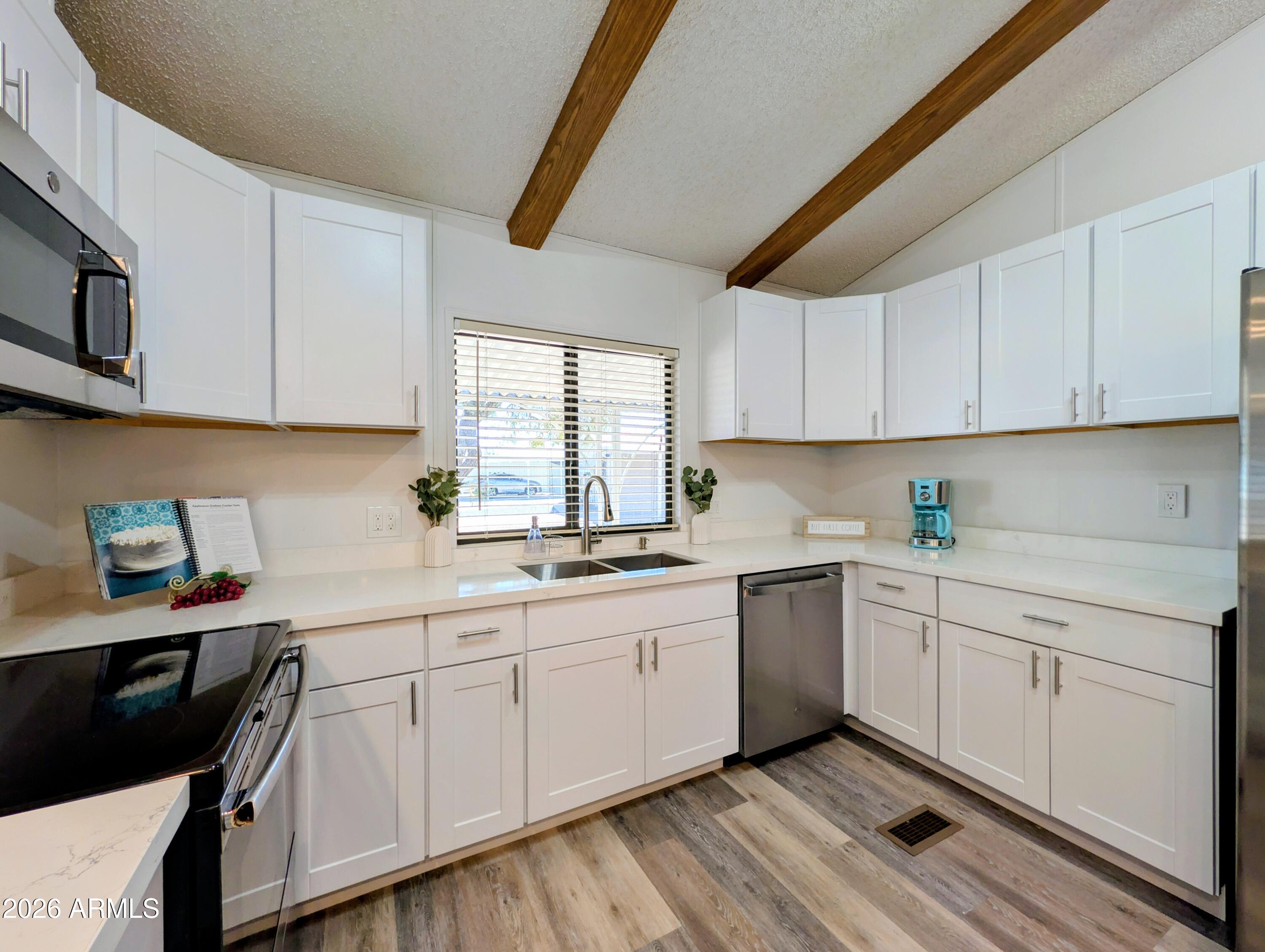 512 South 83rd Way Mesa, AZ 85208 - Photo 4 of 45 a kitchen with a sink dishwasher and white cabinets with wooden floor