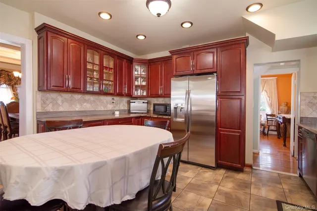 a kitchen with stainless steel appliances kitchen island granite countertop a refrigerator and a sink