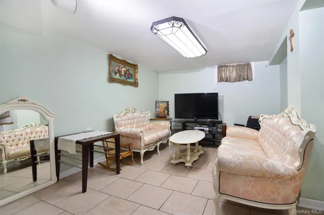 a living room with furniture a flat screen tv and a chandelier