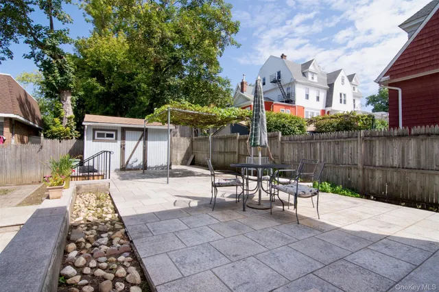 a view of a patio with table and chairs with wooden fence and plants