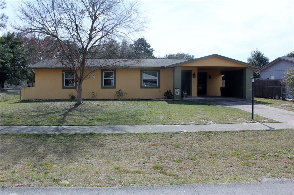 2221 Kent Road Deltona, FL 32738 - Photo 1 of 1 a front view of a house with a yard and trees