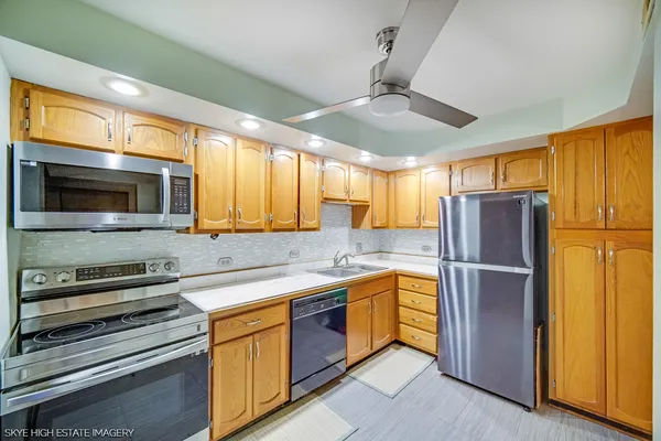 a kitchen with stainless steel appliances granite countertop a refrigerator and a sink