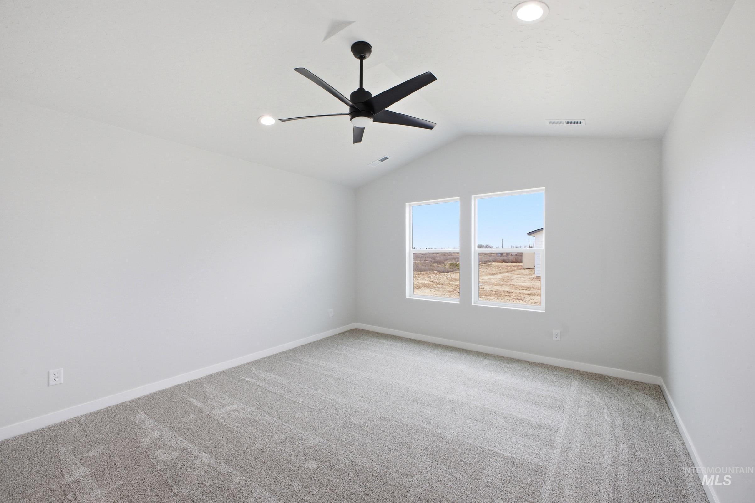 1598 Sunday River Street Middleton, ID 83644 - Photo 14 of 17 Spacious room featuring vaulted ceilings, a contemporary ceiling fan with integrated lighting, two recessed ceiling lights, and two large windows providing ample natural light