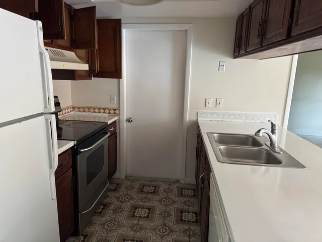 a kitchen with a sink stove and refrigerator
