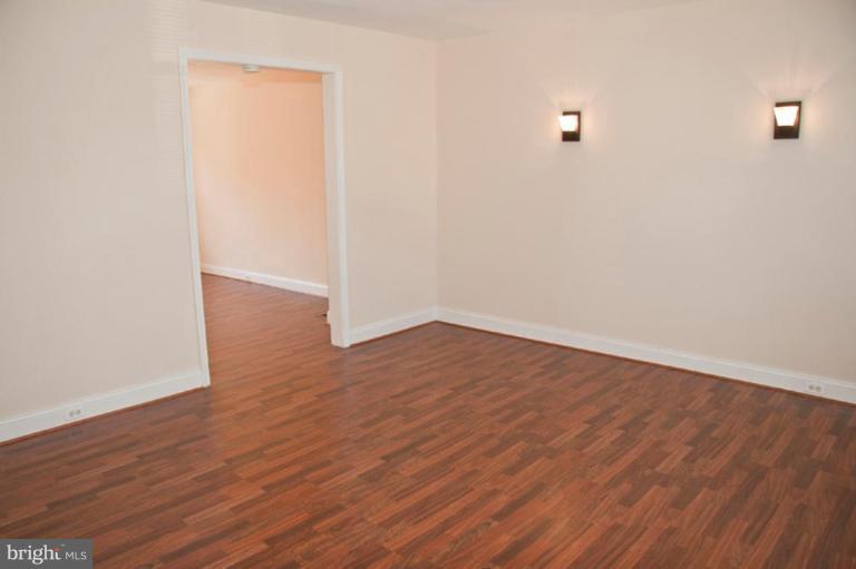 1303 Crofton Road Baltimore, MD 21239 - Photo 2 of 17 an empty room with wooden floor and windows