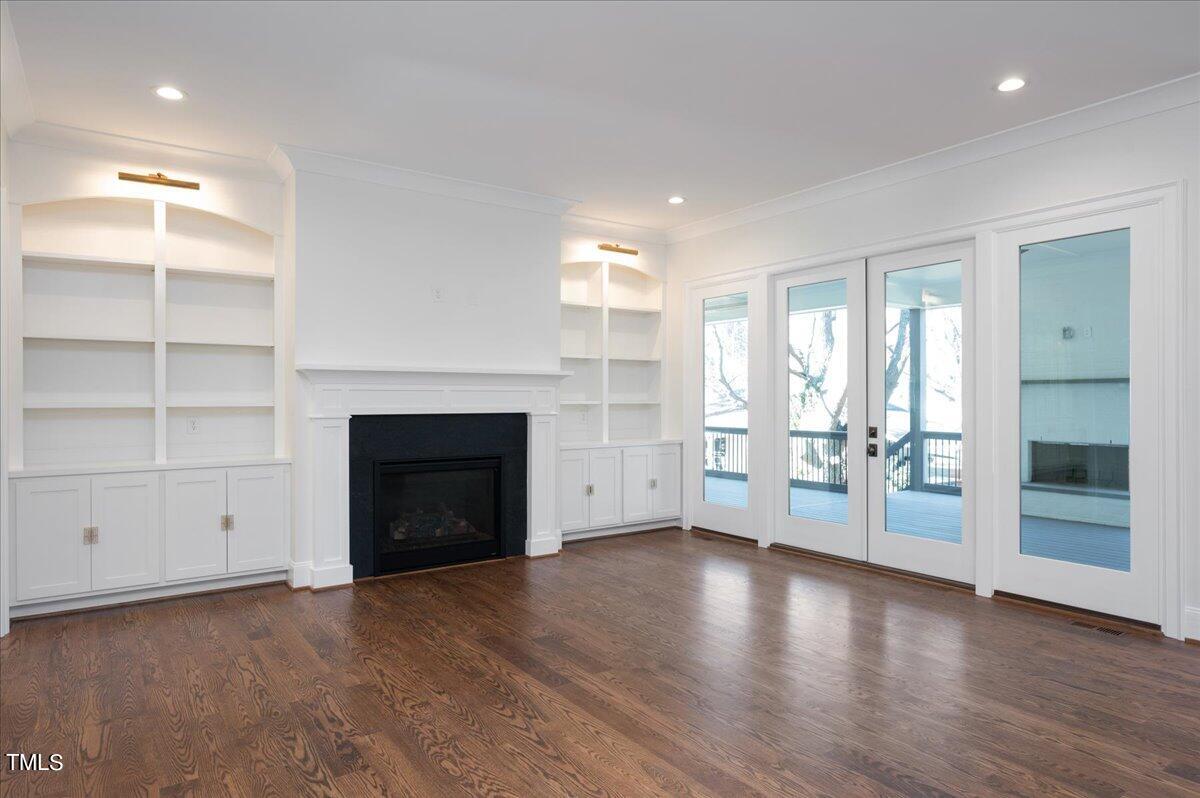 705 Mills Street Raleigh, NC 27608 - Photo 6 of 23 an empty room with wooden floor a fireplace and window