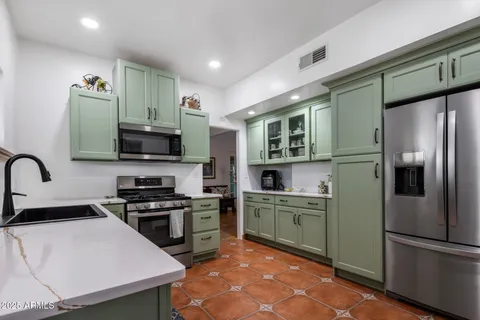 a kitchen with cabinets and stainless steel appliances