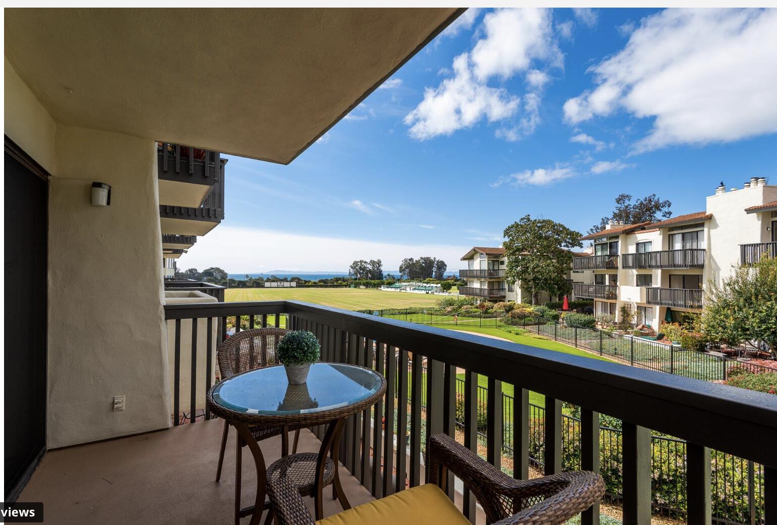 a view of a balcony with furniture and a yard