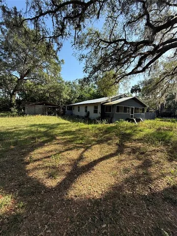 a front view of house with yard and trees in the background