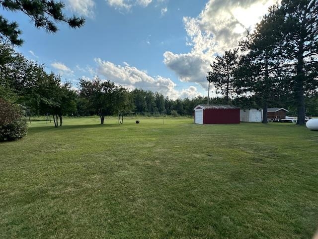 30 Fir Circle Babbitt, MN 55706 - Photo 26 of 27 View of grassy yard featuring a detached garage and an outbuilding