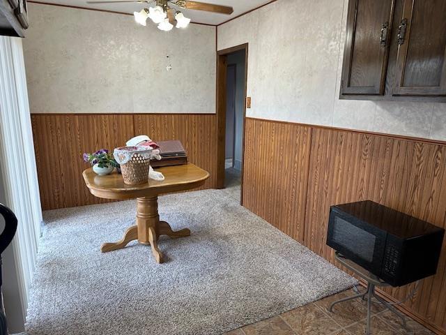 30 Fir Circle Babbitt, MN 55706 - Photo 9 of 27 Carpeted dining room featuring a wainscoted wall, wooden walls, and ceiling fan