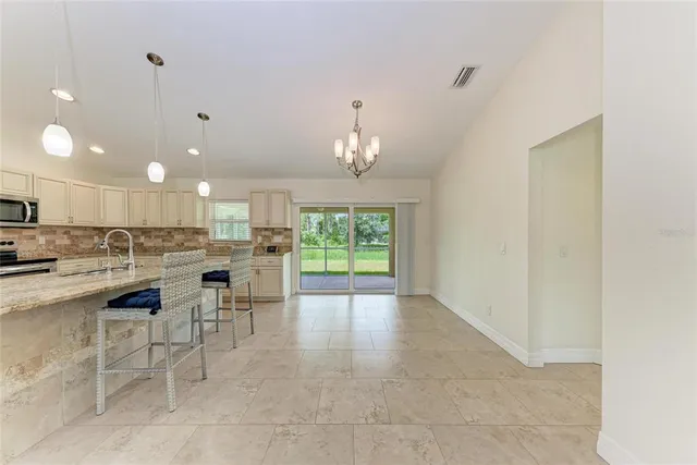 a view of an empty room with a fireplace and a chandelier